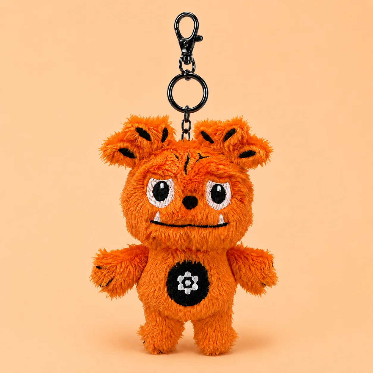 A finished orange character plush keyring shot on its own against a pale orange background